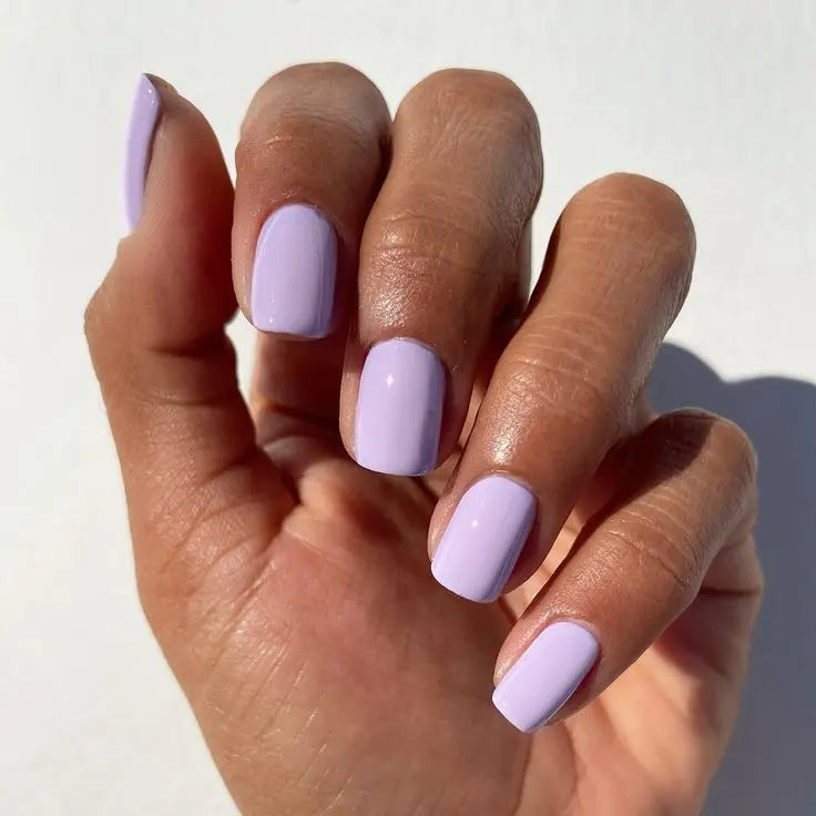 Hand met Lavender Dust nagellak – lichtpaarse vegan crème nagellak met elegante glans voor een verfijnde manicure
